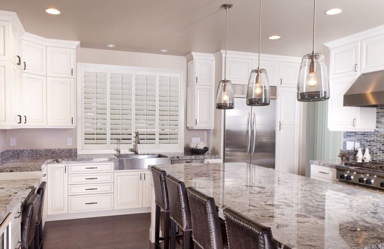 A kitchen window with plantation shutters